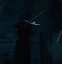 a woman playing a violin in a dark room