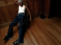a woman laying on a wooden floor in jeans