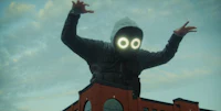 a man in a hoodie is standing on top of a building