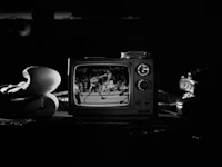 a black and white photograph of a television and boxing gloves