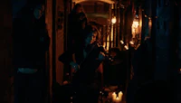 a group of people playing a violin in a dark alley