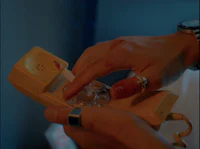 a person's hand is holding a yellow telephone