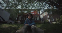 a young boy sitting on steps in front of a house