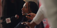 a woman with dreadlocks talking into a microphone