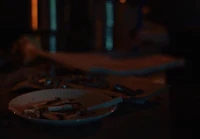 a plate with a cigarette on it sits on a table in the dark