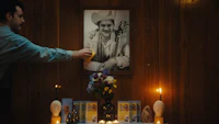 a man is putting candles on a table next to a picture of elvis presley