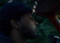 a man sitting in a car with a beanie on his head